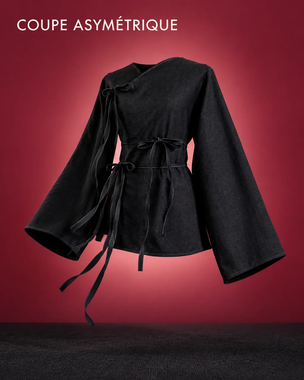 A graphic fashion image built around the exact black asymmetric top from the reference: slanted neck